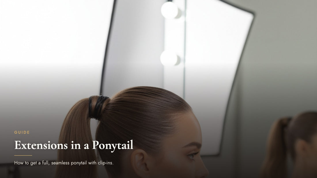 Woman with a sleek high ponytail viewed from the side at a vanity mirror, cover image for how to wear clip-in extensions in a ponytail